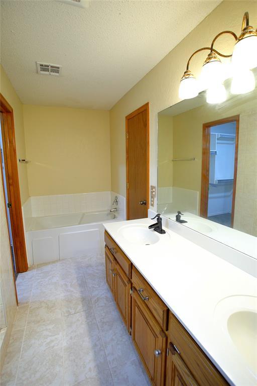 5112 SE 85th St, Oklahoma City, OK 73135 - bathroom with a bath, visible vents, and a sink