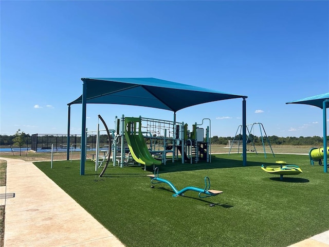 community play area featuring fence and a yard