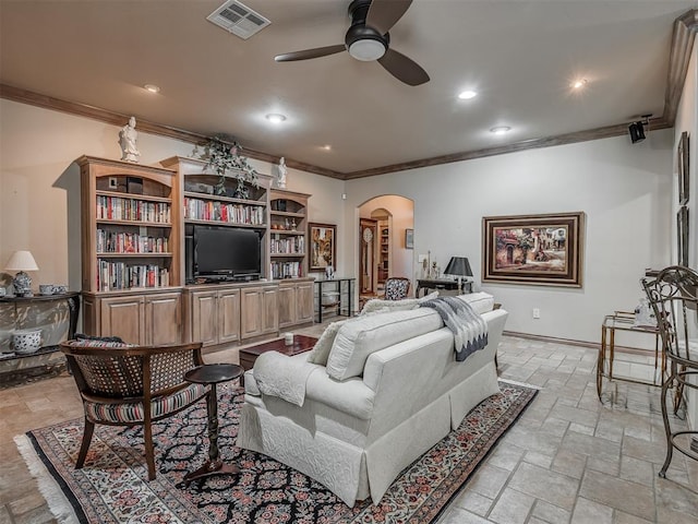 12304 N St Lukes Ln, Oklahoma City, OK 73142 - living room with arched walkways, ornamental molding, ceiling fan, stone tile flooring, and baseboards
