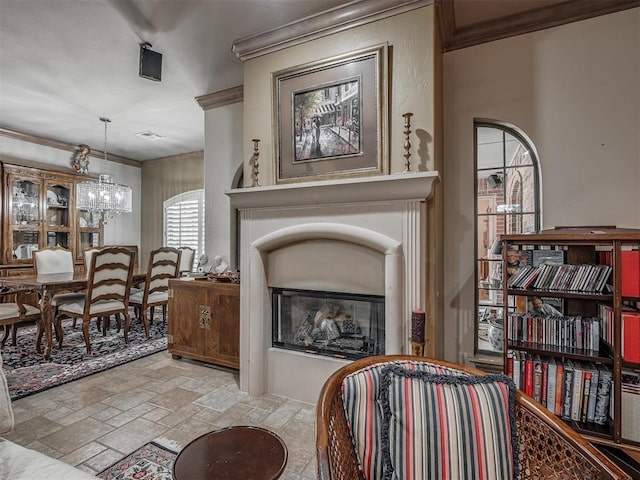 12304 N St Lukes Ln, Oklahoma City, OK 73142 - living area featuring crown molding, stone tile floors, a chandelier, and a glass covered fireplace