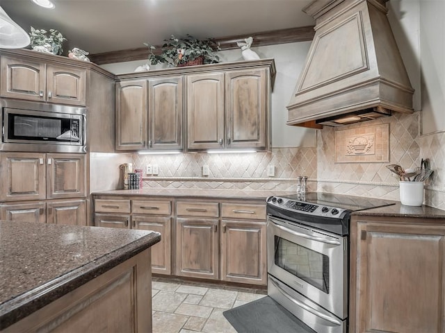 12304 N St Lukes Ln, Oklahoma City, OK 73142 - kitchen featuring appliances with stainless steel finishes, premium range hood, dark stone countertops, and stone tile floors