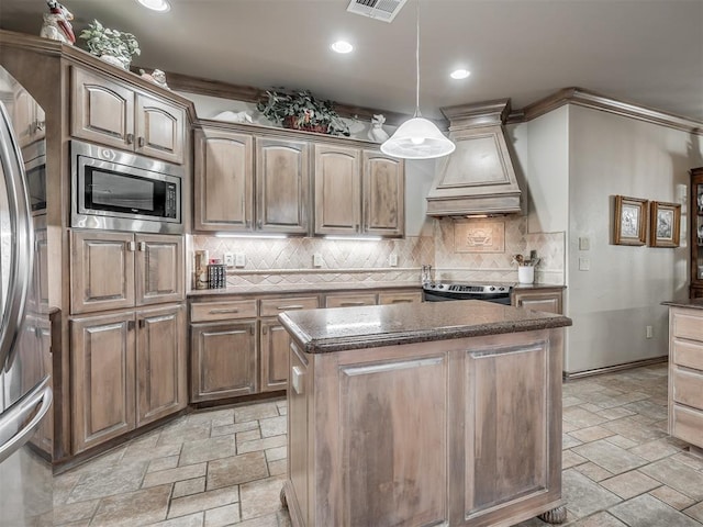12304 N St Lukes Ln, Oklahoma City, OK 73142 - kitchen featuring stainless steel appliances, premium range hood, stone tile floors, a center island, and recessed lighting