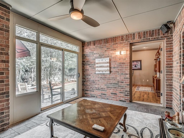12304 N St Lukes Ln, Oklahoma City, OK 73142 - living room featuring brick wall and ceiling fan