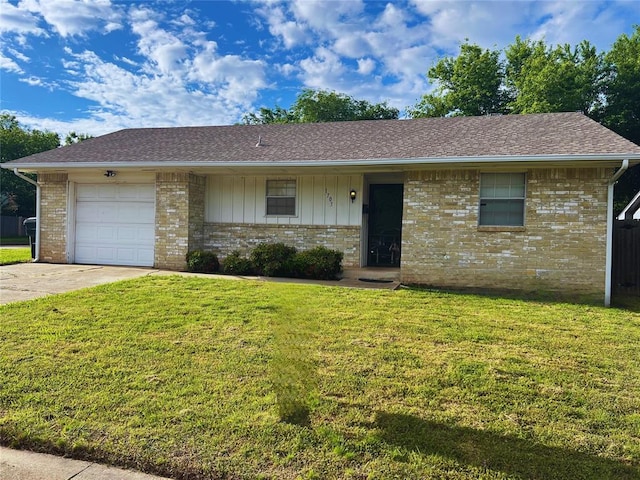 ranch-style home with concrete driveway, a front yard, brick siding, and a garage