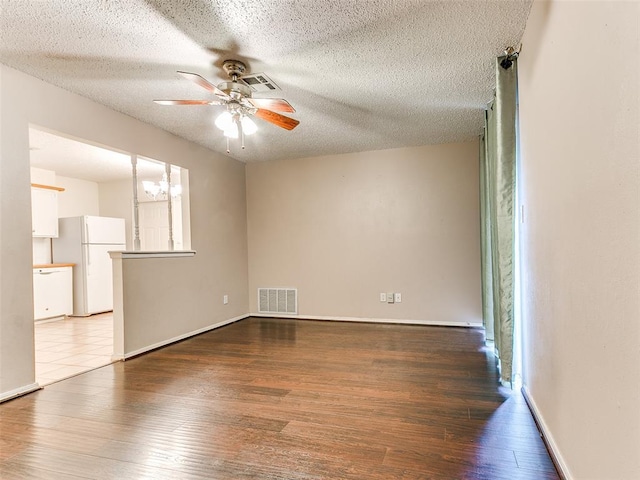 1703 Surrey Pl, Norman, OK 73071 - spare room with a ceiling fan, wood finished floors, a textured ceiling, a chandelier, and baseboards