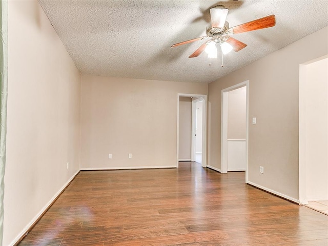 1703 Surrey Pl, Norman, OK 73071 - unfurnished room featuring a textured ceiling, wood finished floors, ceiling fan, and baseboards