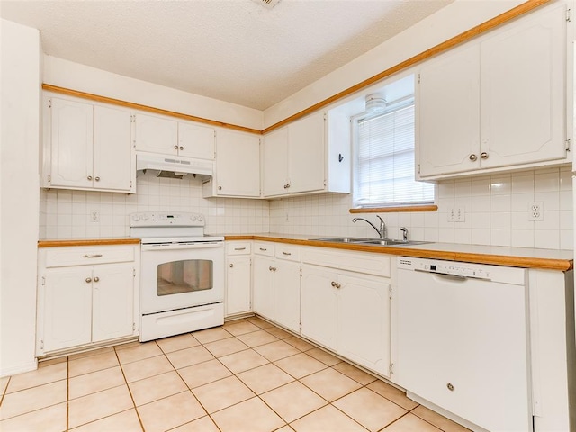 1703 Surrey Pl, Norman, OK 73071 - kitchen featuring white appliances, under cabinet range hood, a sink, decorative backsplash, and a textured ceiling