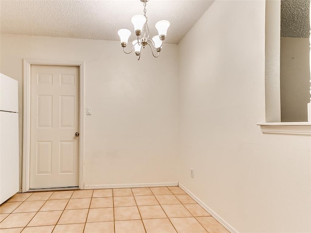 1703 Surrey Pl, Norman, OK 73071 - spare room featuring a chandelier, a textured ceiling, and light tile patterned floors