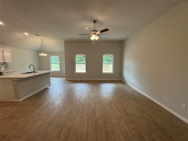 20640 Brush Creek Blvd, Harrah, OK 73045 - unfurnished living room with dark wood-style floors, a ceiling fan, healthy amount of natural light, and a chandelier