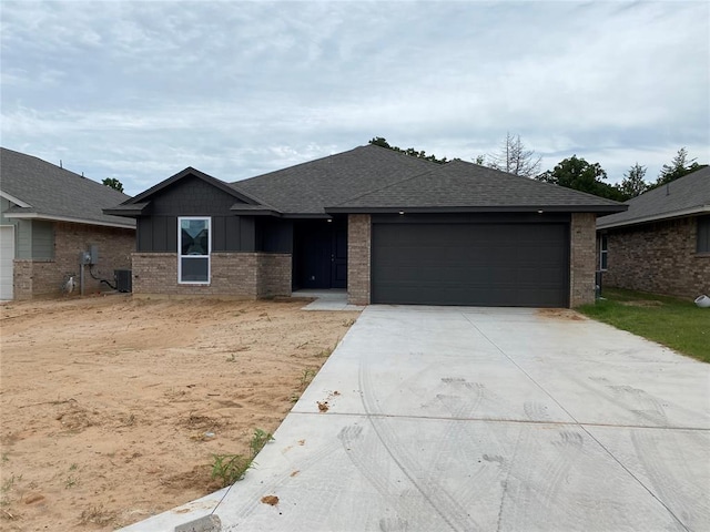 20640 Brush Creek Blvd, Harrah, OK 73045 - view of front facade with a garage, driveway, brick siding, roof with shingles, and board and batten siding