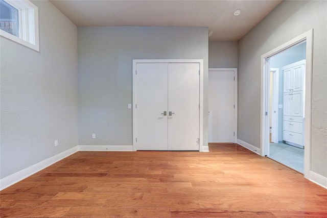 508 Manor Hill Ct, Norman, OK 73072 - unfurnished bedroom featuring baseboards, connected bathroom, light wood finished floors, and a closet