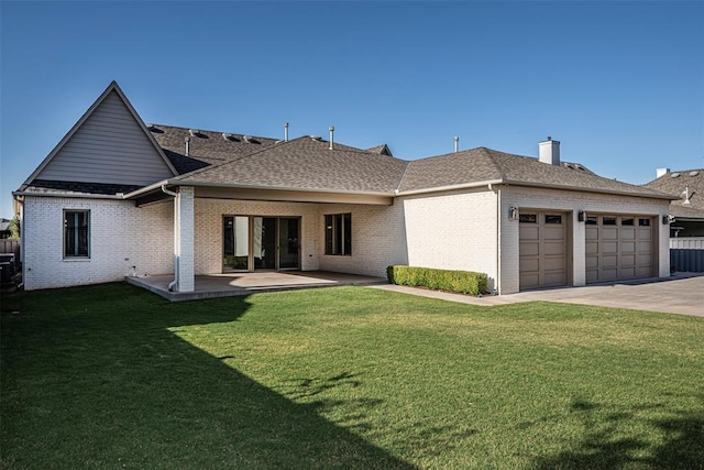 back of property with a lawn, roof with shingles, a garage, and brick siding