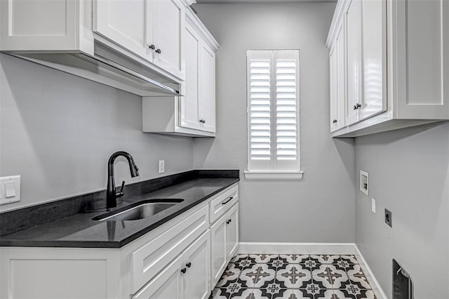 washroom with tile patterned floors, cabinet space, washer hookup, a sink, and baseboards
