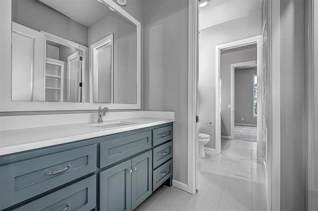 bathroom with vanity, toilet, and baseboards