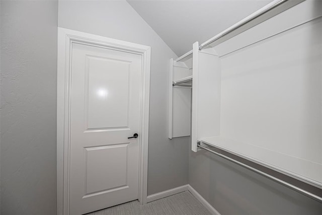 spacious closet featuring light carpet and lofted ceiling