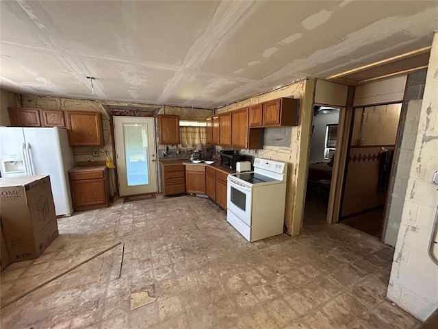 kitchen featuring brown cabinetry, a sink, and white appliances