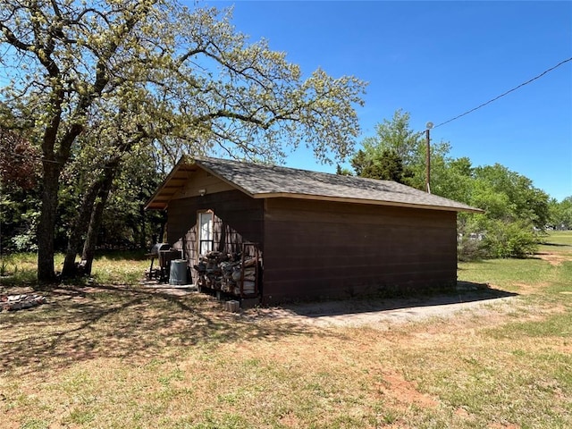 view of side of home with an outdoor structure, a storage shed, and a yard