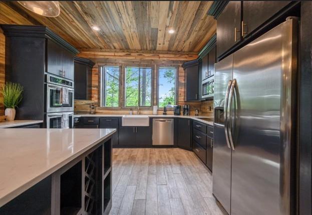 kitchen with light wood finished floors, recessed lighting, wood ceiling, light countertops, and appliances with stainless steel finishes
