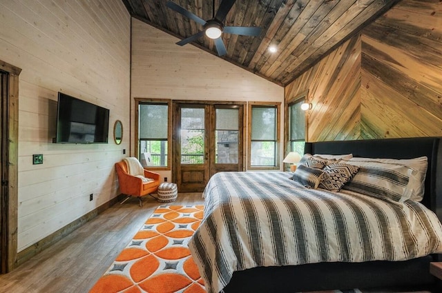 bedroom featuring baseboards, wood walls, wood ceiling, hardwood / wood-style flooring, and high vaulted ceiling