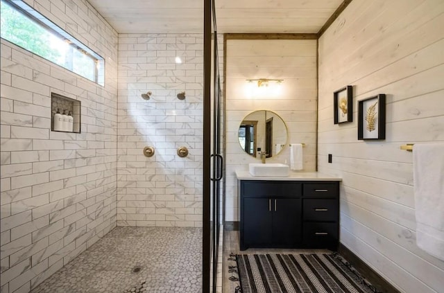 full bathroom featuring vanity, wooden walls, and a stall shower