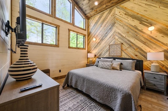 bedroom featuring vaulted ceiling, wood walls, wooden ceiling, and light wood-style flooring