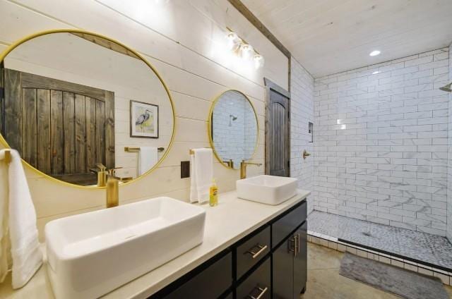 full bathroom featuring tile patterned flooring, a sink, double vanity, and tiled shower
