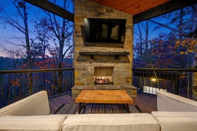 deck with an outdoor living space with a fireplace