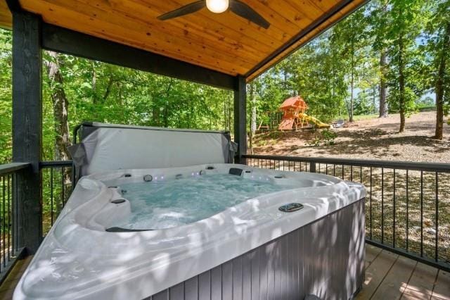 wooden deck featuring a ceiling fan and a hot tub