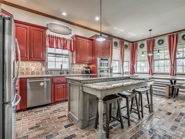 10711 Crystal Creek Dr, Mustang, OK 73064 - kitchen featuring ornamental molding, a sink, brick floor, decorative backsplash, and appliances with stainless steel finishes