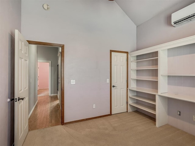 10711 Crystal Creek Dr, Mustang, OK 73064 - unfurnished bedroom featuring light carpet, baseboards, an AC wall unit, and high vaulted ceiling