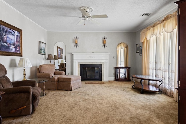 living room with arched walkways, a textured ceiling, visible vents, and carpet flooring
