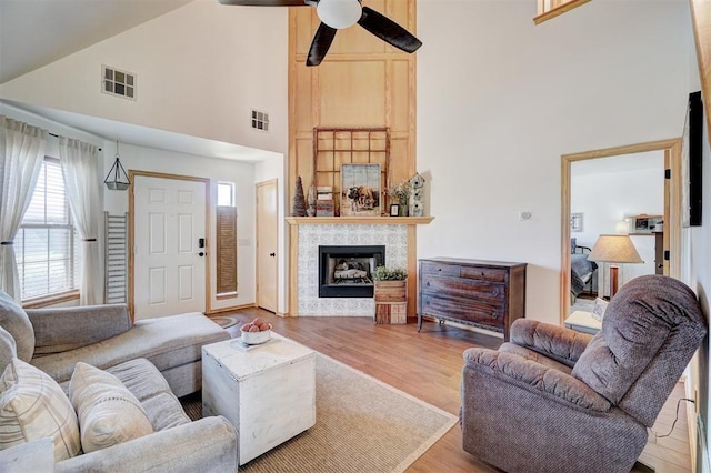 1409 SW 23rd St, Moore, OK 73170 - living area with wood finished floors, visible vents, high vaulted ceiling, and a tile fireplace