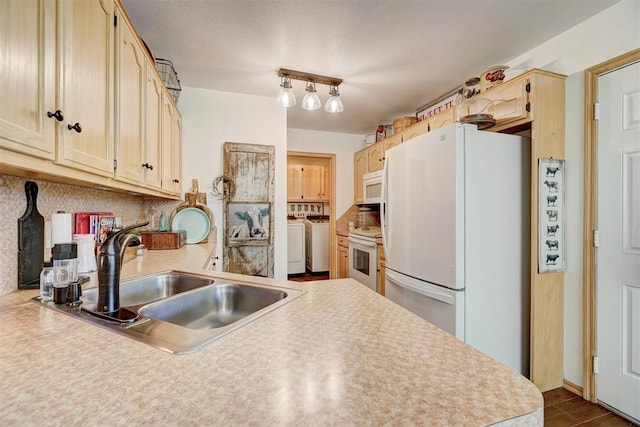 1409 SW 23rd St, Moore, OK 73170 - kitchen featuring washer and dryer, white appliances, a sink, and backsplash