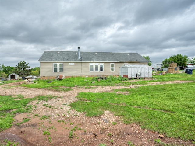 4124 E Horseshoe Ln, Moore, OK 73160 - rear view of house featuring a lawn, a shed, and an outbuilding