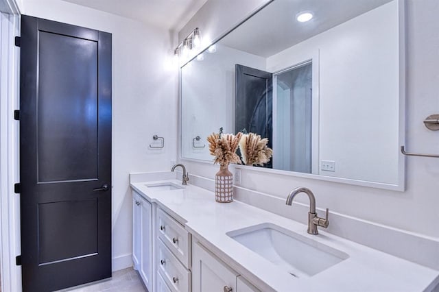 bathroom with tile patterned floors, recessed lighting, double vanity, and a sink