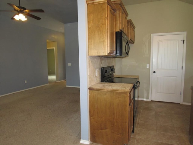 kitchen featuring brown cabinetry, tile countertops, a ceiling fan, backsplash, and black appliances