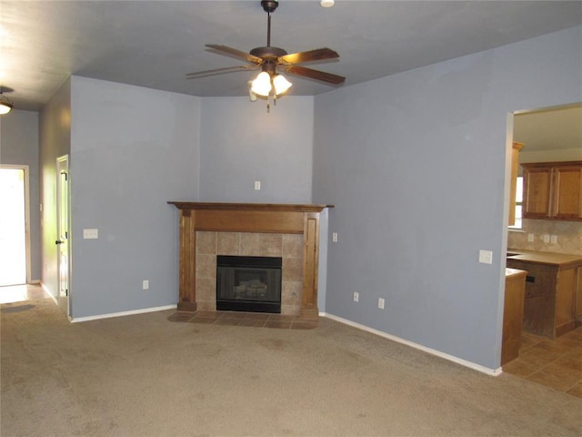 900 Aspen Creek Ter, Yukon, OK 73099 - unfurnished living room featuring a ceiling fan, light colored carpet, and a tiled fireplace