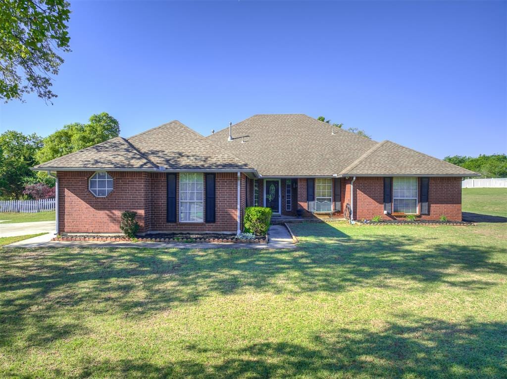 15152 Scottsdale Ln, Choctaw, OK 73020 - ranch-style home featuring fence, brick siding, a front yard, and roof with shingles
