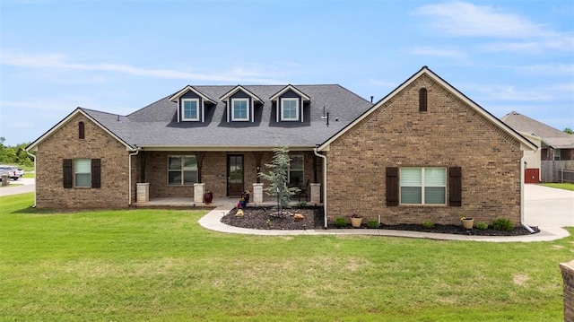 view of front facade with brick siding, a front yard, and concrete driveway