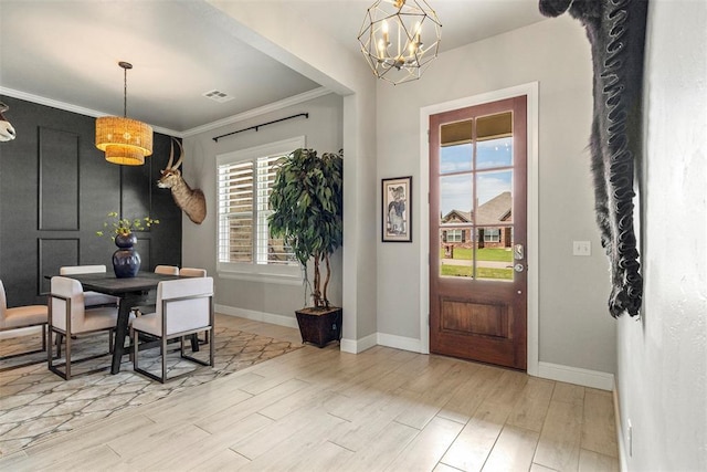 dining room with a chandelier, plenty of natural light, baseboards, and crown molding