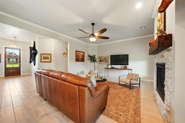 living area with a stone fireplace, a ceiling fan, ornamental molding, a chandelier, and baseboards