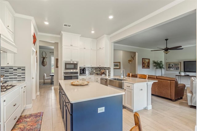 kitchen featuring a sink, open floor plan, a peninsula, white cabinetry, and recessed lighting