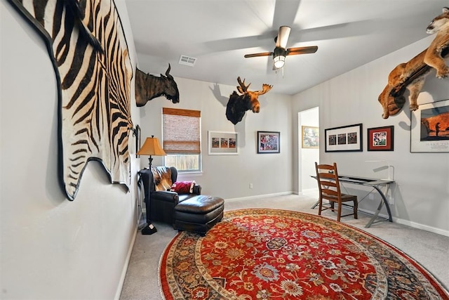 sitting room featuring carpet floors, baseboards, and ceiling fan