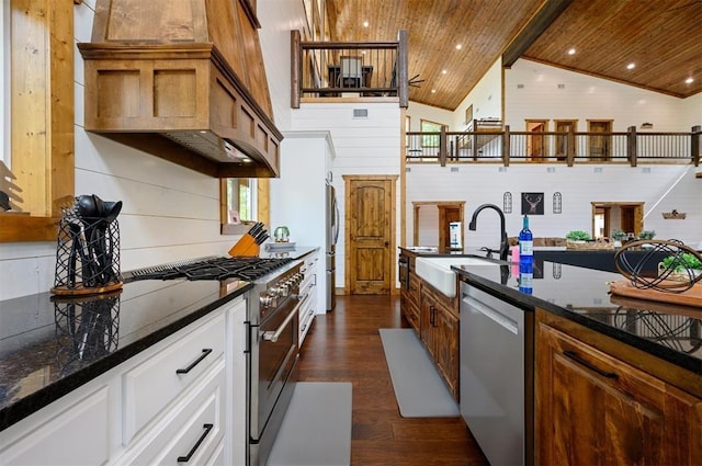 kitchen featuring appliances with stainless steel finishes, a sink, wooden ceiling, dark stone countertops, and dark wood-style floors
