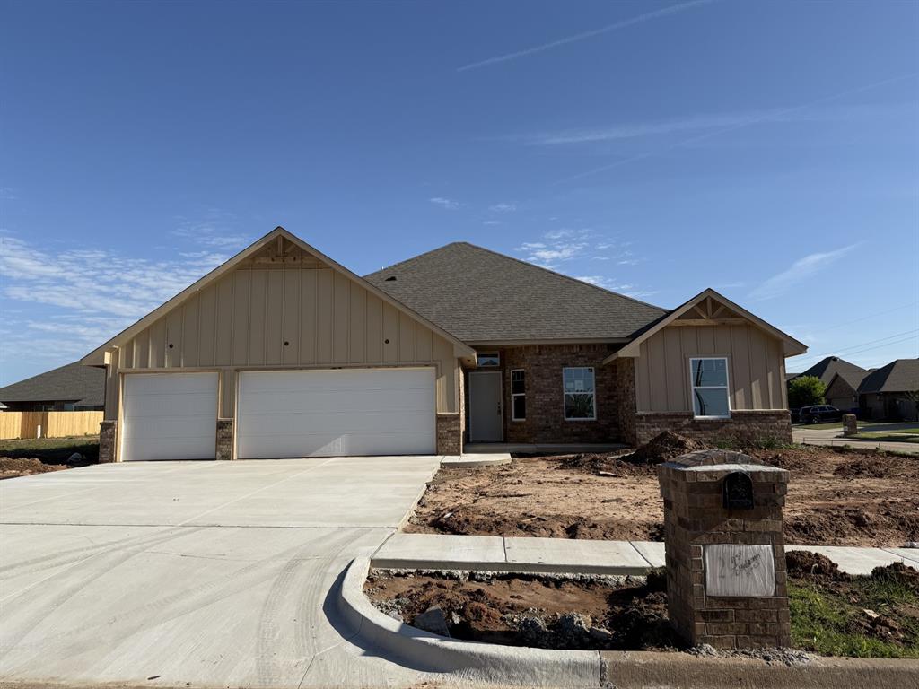 ranch-style house featuring roof with shingles, board and batten siding, an attached garage, driveway, and brick siding