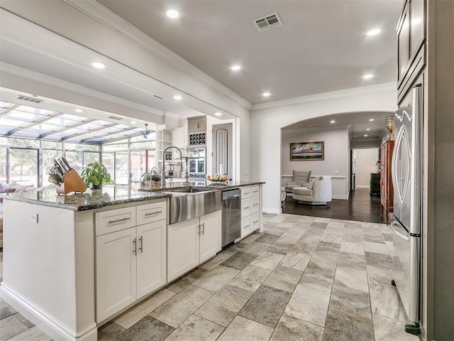6363 NW 220th St, Edmond, OK 73025 - kitchen with stainless steel appliances, a sink, open floor plan, visible vents, and ornamental molding