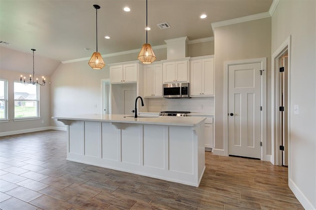 3404 Slate River Dr, Yukon, OK 73099 - kitchen featuring stainless steel microwave, a sink, decorative backsplash, baseboards, and a center island with sink
