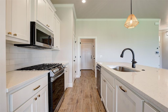 3404 Slate River Dr, Yukon, OK 73099 - kitchen with appliances with stainless steel finishes, a sink, ornamental molding, white cabinetry, and light stone countertops