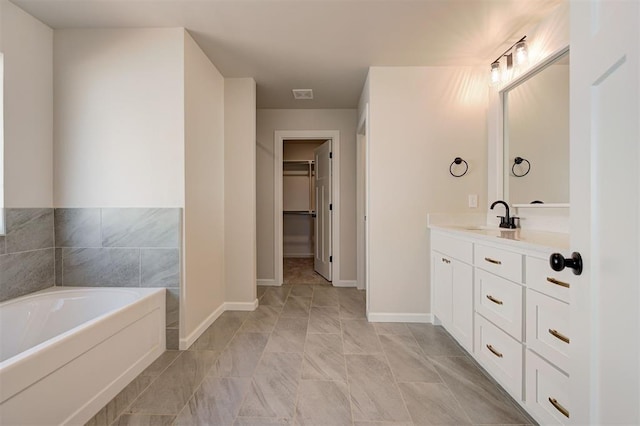 3404 Slate River Dr, Yukon, OK 73099 - full bath featuring vanity, a walk in closet, a bath, and baseboards
