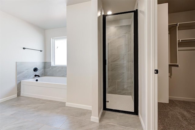 3404 Slate River Dr, Yukon, OK 73099 - full bath with a spacious closet, a stall shower, a bath, baseboards, and tile patterned floors
